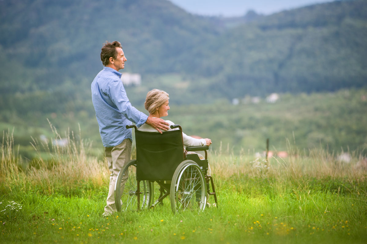 senior-man-with-woman-in-wheelchair-green-autumn